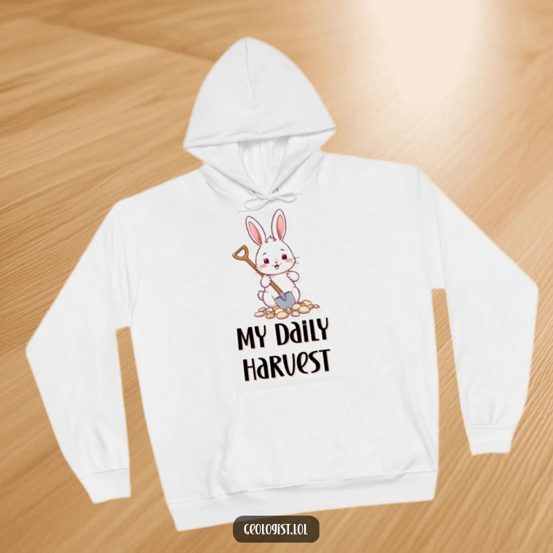 Funny hoodie featuring a cheerful rabbit with a tiny shovel, gathering pebbles, perfect for cozy garden vibes.