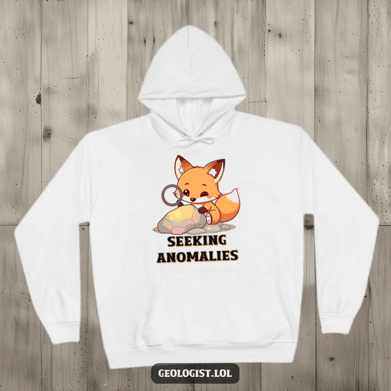 Funny hoodie featuring a curious fox holding a magnifying glass and examining a colorful rock, great for warmth.